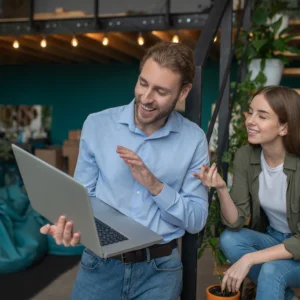 Mann zeigt einer Frau etwas auf seinem Laptop