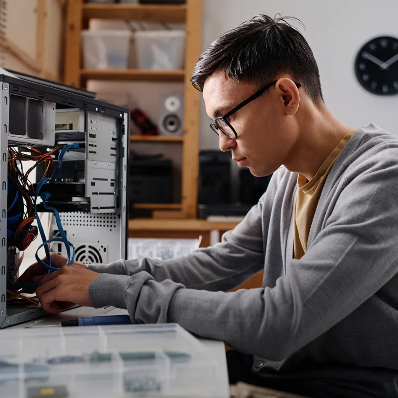 Ein junger Mann schraubt ein Computer zusammen